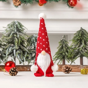 Nordic Christmas gnome with red knitted heart hat and white beard in festive setting