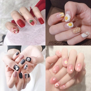 Detail view of colorful press-on nails in strawberry, floral, and checkered patterns