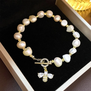 Macro shot of baroque pearl bee bracelet with zircon encrusted toggle clasp in jewelry box