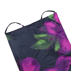Detail shot of purple floral print on black satin fabric with slim shoulder straps