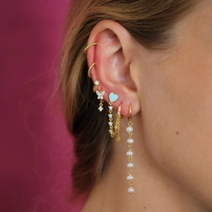 Close-up of gold ear jewelry set featuring butterfly studs and pearl tassel chain earrings