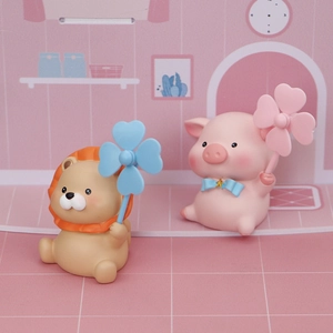 Close-up of cute lion and pig figurines with clover windmills in a pink scene