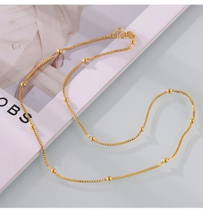 Close-up of a gold-plated titanium steel box chain necklace with small bead accents