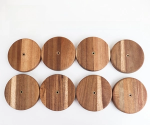 Detailed top view of eight circular walnut wood bases with gold threaded metal inserts