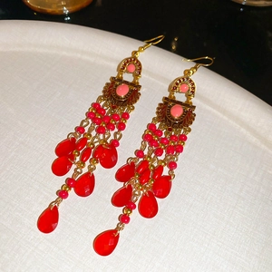 Detailed macro view of red water drop fringe earrings in vintage bohemian style