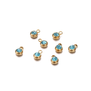 Détail de pendentifs en acier inoxydable doré avec pierres de zircone bleu clair