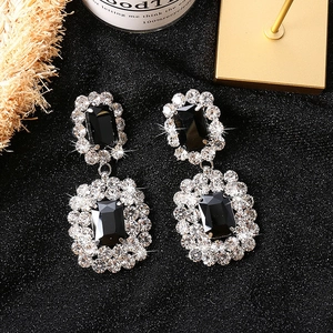Dettaglio di orecchini vintage con pietre nere e aloni di diamanti scintillanti