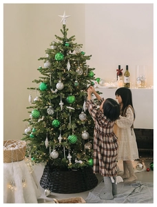 Detailed scene of children decorating a faux Christmas tree with woven wicker basket base