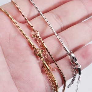 Polished stainless steel box chains in gold, rose gold and silver on a hand