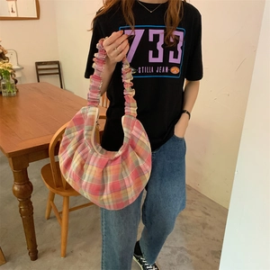 Detail of pink and yellow checkered crescent bag with a scrunchie-style shoulder strap