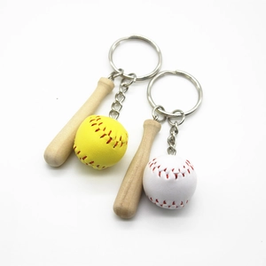 Detail of mini wooden baseball bat keychain with realistic yellow and white softballs
