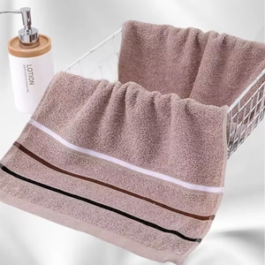 Close-up of thick brown striped cotton towel draped over a metal mesh basket