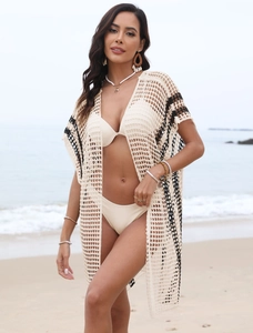 Detail of crochet beach cover-up with hollow knit patterns and black stripe accents