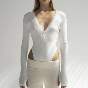Detail of white ribbed knit bodysuit featuring deep V-neckline and button front closure