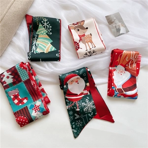 Detailed view of various Christmas themed narrow silk scarves in festive red and green