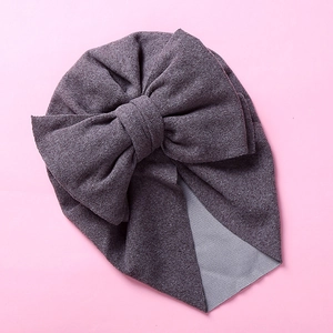 Macro detail of elastic soft knit baby turban hat with a large decorative bow