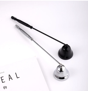 Detail of matte black and polished silver candle snuffers with flexible bell-shaped caps