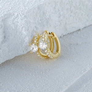 Macro detail of gold S925 silver hoop earrings with four-prong set sparkling zircons