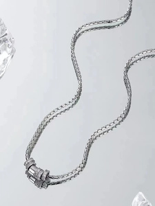 Close-up of titanium steel snake chain with three sparkling diamond-encrusted cylinder charms