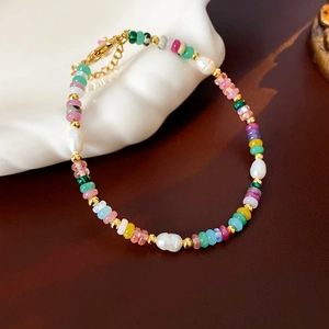 Detailed macro view of colorful baroque pearls and 18K gold plated clasp on the bracelet