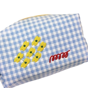Blue and white plaid makeup bag with heart embroidery and yellow zipper on white background