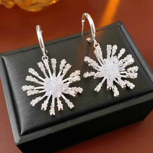 Macro des boucles d'oreilles pendantes en C argentées avec motifs étoile et flocon en zircon