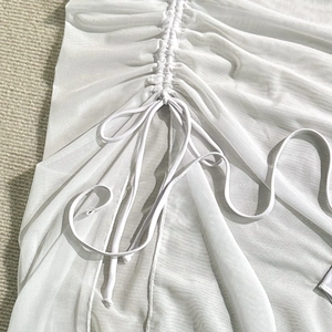 Detail of white mesh fabric with adjustable drawstring and ruched texture for beachwear
