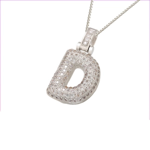 Macro view of iced out silver letter D pendant with cubic zirconia on box chain