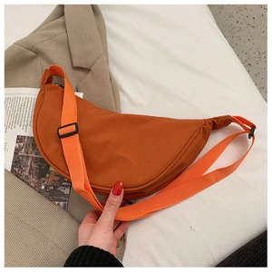 Detail of an orange crescent nylon crossbody bag with an adjustable wide shoulder strap
