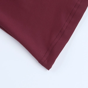Detail of burgundy knit fabric showing reinforced double-stitching on the hemline