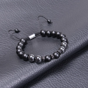 Detailed macro of 10mm tiger eye and lava stone braided bracelet with adjustable cord