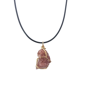 Detail of pink natural crystal pendant with gold wire wrap on a black cord necklace