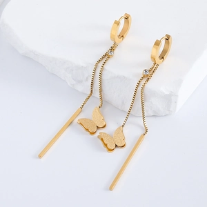 Detailed view of gold butterfly tassel earrings with long bars and crystal accents