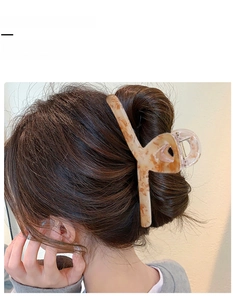 Grande pince à cheveux ambre miel fixant un chignon complet avec élégance chic