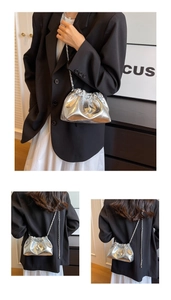 Three views of a silver pleated cloud bucket bag with metallic chain strap on a model