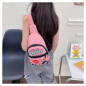 Pink school bus chest bag for kids worn by a child in a cozy indoor setting