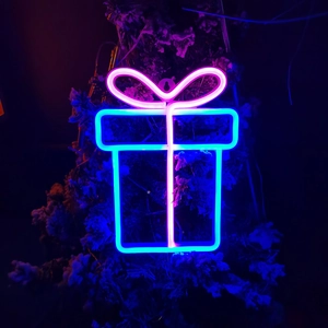 Detail of pink and blue neon gift box light glowing in dark holiday setting