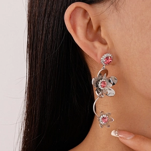 Elegant silver tassel earrings with pink zircon flowers worn on model in a side profile view