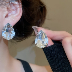 Detailed macro view of large teardrop crystal earrings with multi-faceted diamond shine