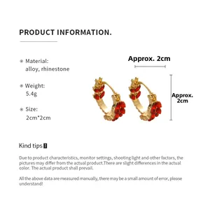 Detail showing dimensions of vintage gold U-shaped earrings with red rhinestones