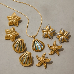 Macro shot of gold and silver starfish earrings with abalone shell inlays