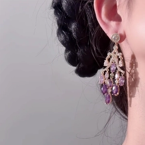 18K gold plated drop earrings featuring purple zircons worn by a model in profile view