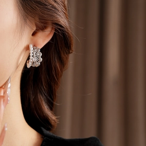 Macro shot of vintage lace-style pearl earrings with zircons on model ear