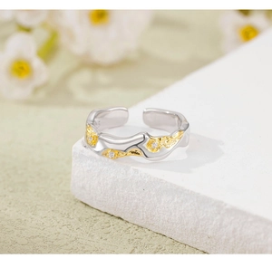 Detail of 925 silver lava texture ring with zircons on a white decorative stone