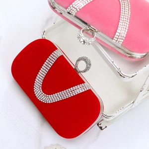 Detail of luxury velvet evening clutch bags in red and pink with sparkling diamond buckles