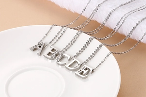 Detailed view of silver capital letters A to E necklaces with sparkling crystals