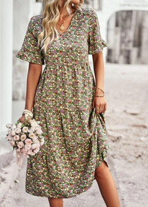 Close-up of green floral print V-neck dress featuring short sleeves and tiered hem details