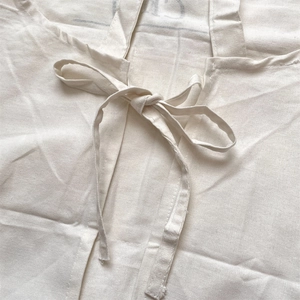 Macro shot of minimalist cotton linen apron with detailed beige bow tie and neat stitching