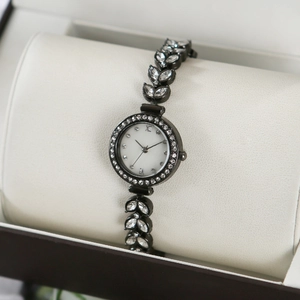 Detail of mermaid watch with leaf-shaped rhinestone strap and roman numeral dial