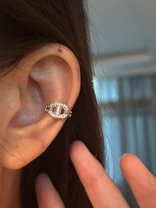 Detail of silver pig nose ear cuff with pavé cubic zirconia on the ear cartilage